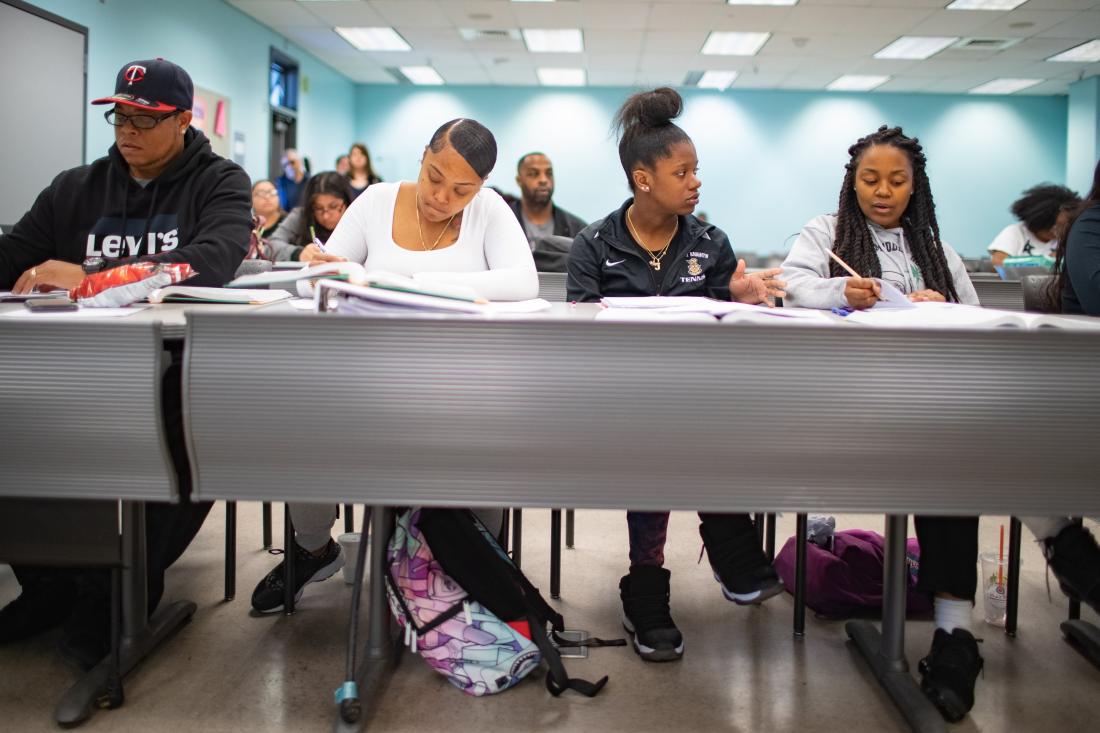 Four Students in Classroom Taking Notes